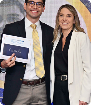 Dos colaboradores de BICE posan sonrientes durante una ceremonia de reconocimiento corporativo