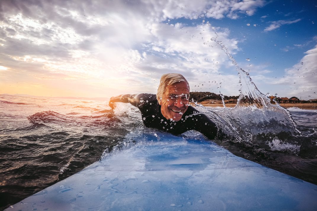 Un hombre mayor haciendo surf.