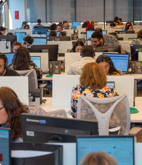 Equipo de colaboradores trabajando en un espacio de oficina abierta con múltiples estaciones y computadores