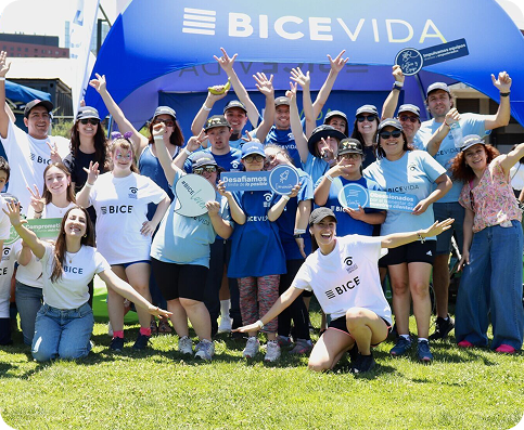 Equipo de BICE Vida participando en una actividad al aire libre, posando juntos frente a un stand corporativo